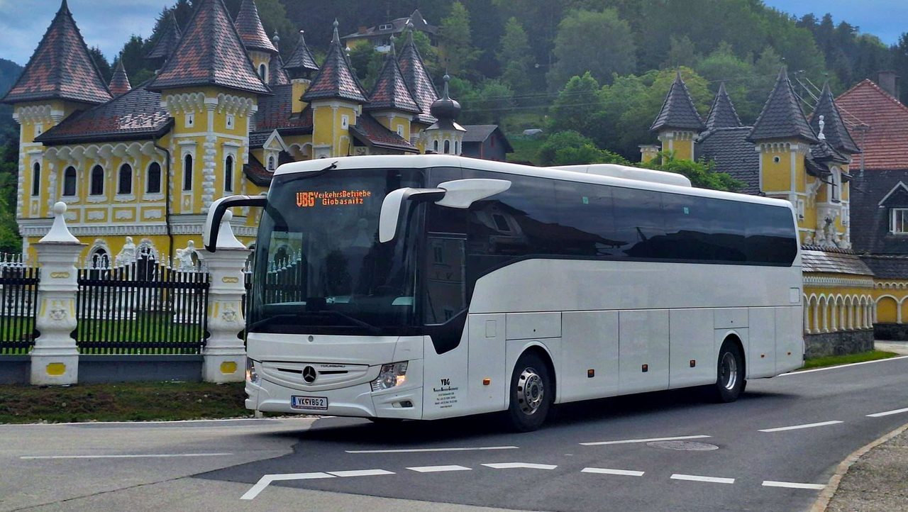 VBG-Reisebus der VerkehrsBetriebe Globasnitz auf Fahrt vor einem Schloss in Kärnten